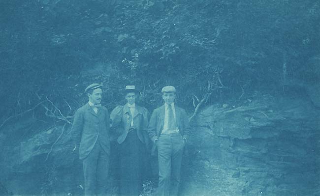 Anonymous - Two Men and a Woman Standing in Front of a Rock Wall