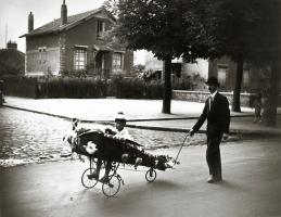 Robert Doisneau - Concours de Chars Fleuris, Choisy le Roi (Man and Boy in Flower Decorated Airplane)