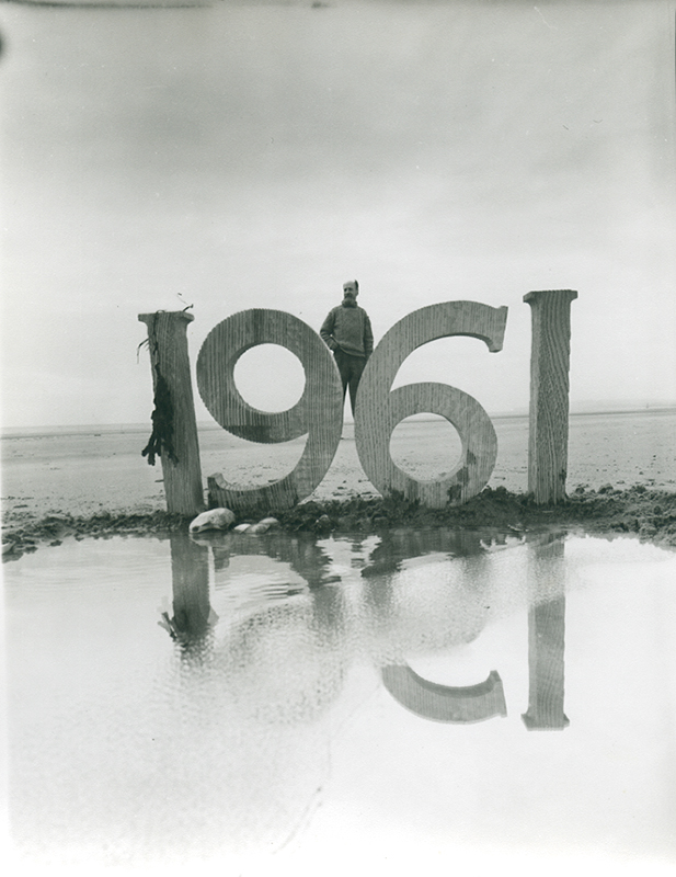 Angus McBean - Christmas Card 1961 - Self Portrait with Wooden Letters on the Beach Angus McBean - Christmas Card 1961 - Self Portrait with Wooden Letters on the Beach