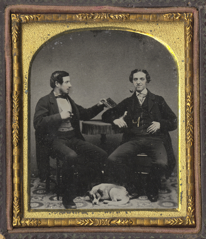 Anonymous, British - Two Men at a Table with a Dog at their Feet, One Man Holding a Cased Image Anonymous, British - Two Men at a Table with a Dog at their Feet, One Man Holding a Cased Image