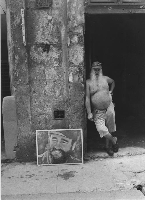 Man Standing Beside Poster of Fidel, Cuba