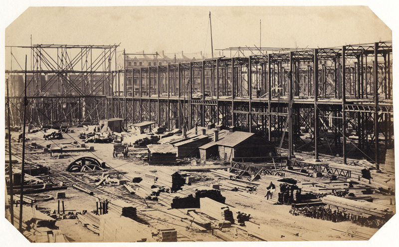 Construction of the 1862 International Exhibition at South Kensington [Early Construction View with Man & Child Sitting on Lumber]